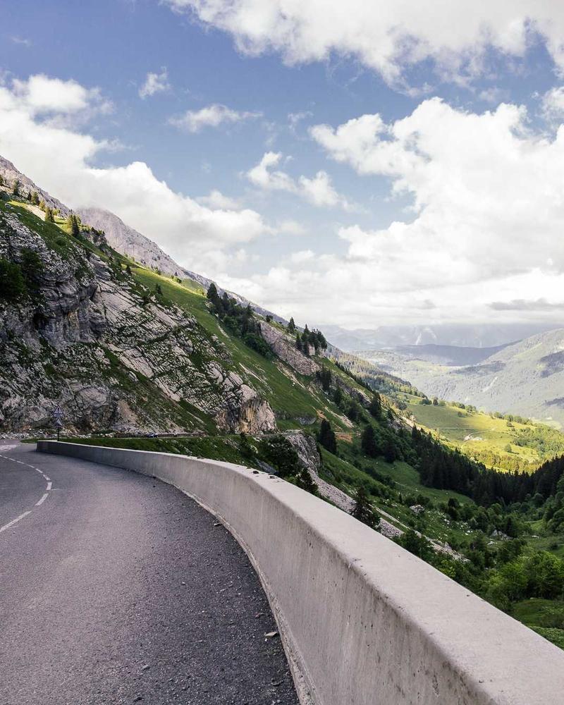 A road cut into a mountainside under a wide sky.