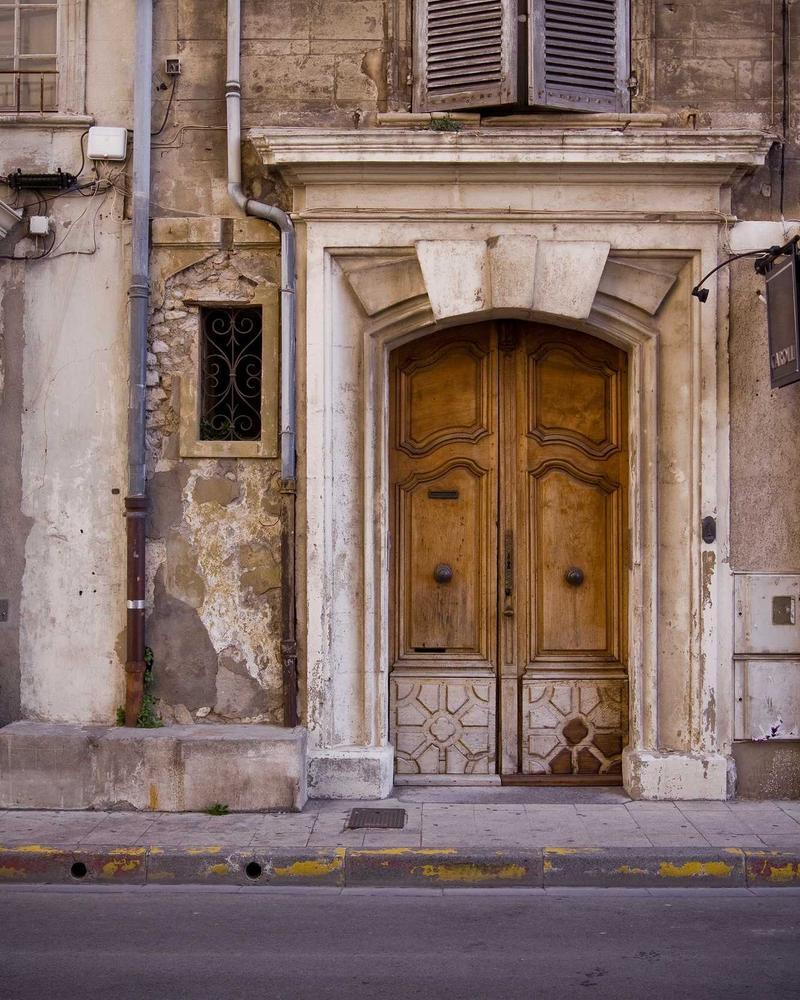 A weathered stone doorway with a carved wooden door.